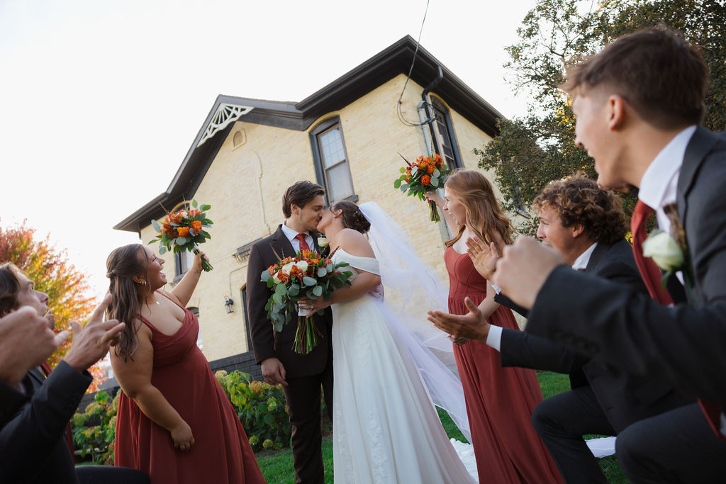 newlyweds with bridal party at rustic wedding venue in wisconsin