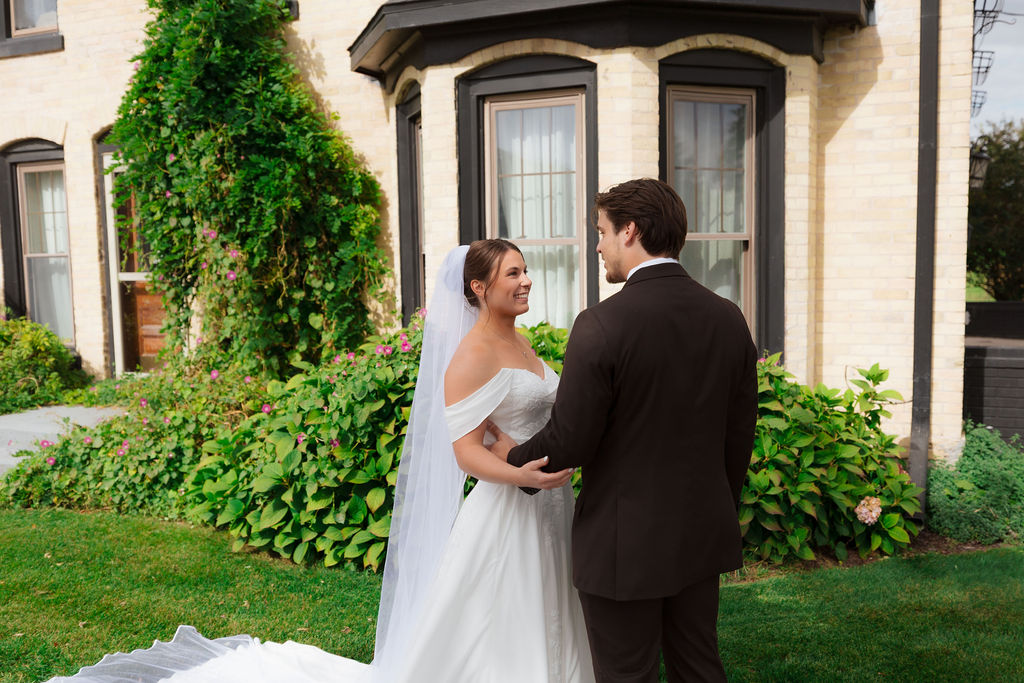 bride and groom standing in front of farmhouse rustic wedding venue