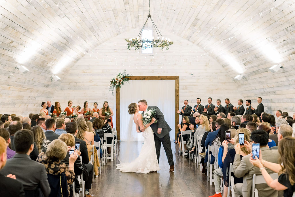 bride and groom kissing at their wisconsin barn wedding at an indoor ceremony